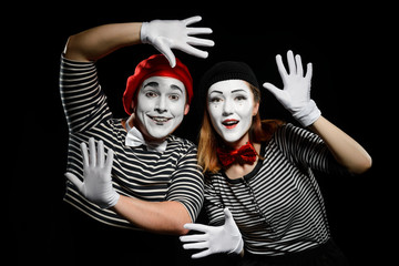 Smiling mimes in striped shirts. Man and woman, dressed as actors