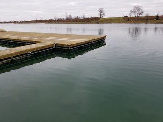 Public lake with wooden dock walkway and overcast sky