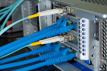 Lan and fiber optic cables are plugged into the back panal of the server.