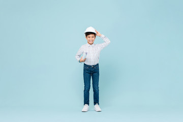 Smiling Asian boy wearing engineer hardhat and holding blueprint