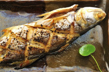 High angle shot of roasted fish on the plate