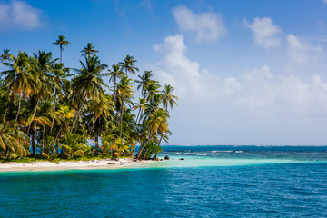Palm island with beach and turquoise blue ocean