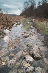 Rocks on the flooded road by the lake