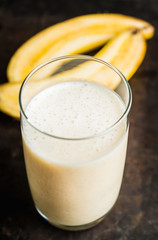 Banana milkshake with on the rustic background. Selective focus.