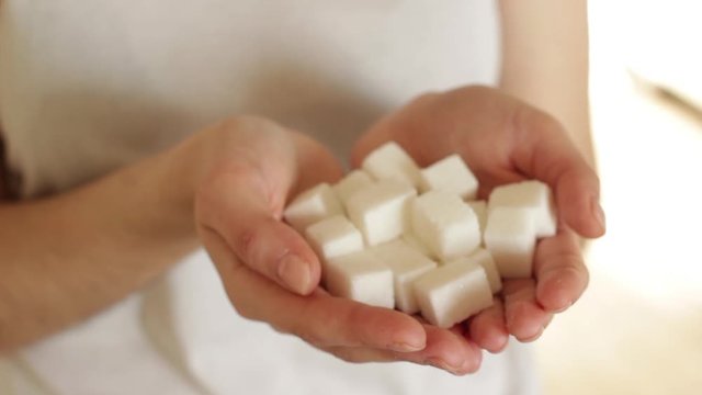 handfull of white sugar cubes on white background