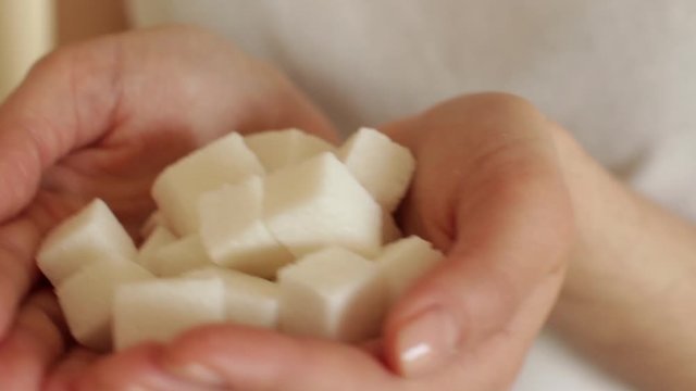 handfull of white sugar cubes on white background