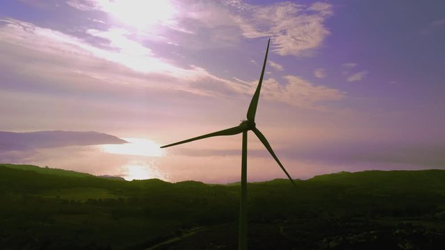 The Wind Mill station and the beautiful pinkish and purplish skies reflect in the beach of Barizo Beach, Spain - wide shot