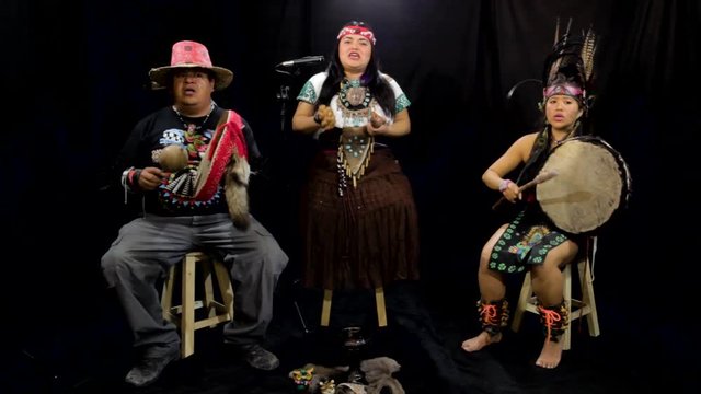 group of shaman Teotihuacanos, Xicalanca - Toltec in black background, with traditional dress dance with a trappings with feathers and drum