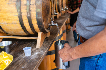Un trabajador está llenando el vaso de tequila para brindarle a los turistas.