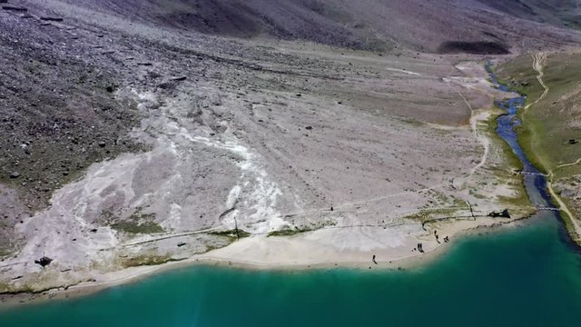 Aerial shot of people standing at the shore of chandratal lake , spiti valley