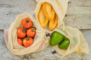Fresh bread, avocado and tomatoes in a reusable bag on a stylish wooden kitchen surface. Zero waste concept