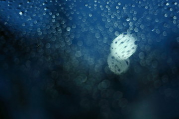 water rain drop on glass window with blur street light in night town background