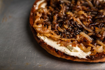 Homemade pizza with goat cheese, caramelized onion and balsamic vinegar. Selective focus. Shallow depth of field.