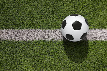 Top view white soccer ball with line on soccer field background.