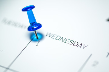 Blue push pin on the 1st  date of the calendar Wednesday - 1st of April Wednesday - April fools day 2020