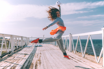 Hip hop dancer in fashion sportswear jumping and dancing in the street
