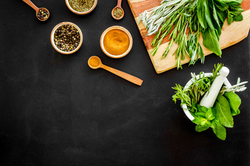 Herbs and spices on black kitchen desk top-down copy space