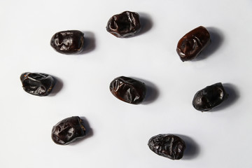 Dried dates fruits on white background. Minimal healthy sweet food, studio shooting, flat lay, top view