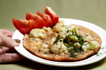 Cooking. Frying Broccoli, eggs and peaces of red tomato on the plate