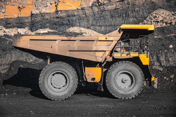 Big yellow mining truck body loaded anthracite. Open pit mine, extractive industry for coal