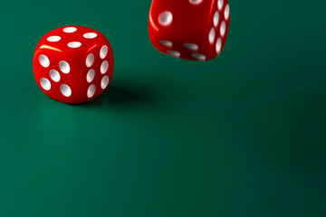 Red dice on green background close up