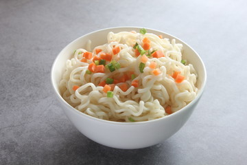 Instant noodles in a bowl isolated on dark background.