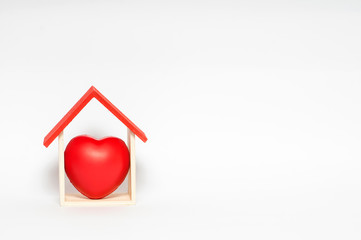 Home sweet home. Heart shape in wooden house with white background copy space