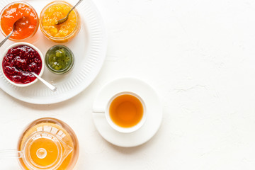Fototapeta na wymiar Fruit jam near tea on white kitchen desk frame copy space