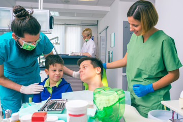 Professional dentist team and two young boys as patients at the dental office