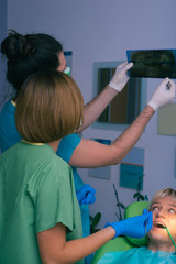 Male dentist showing the diagnosis of the x-ray picture to his colleague