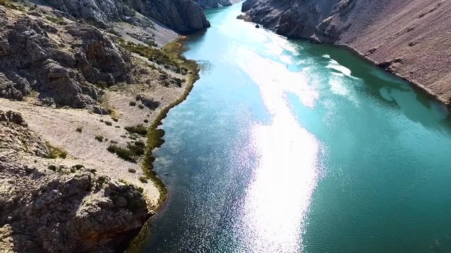 flying through valley with a river and bright sky // push out