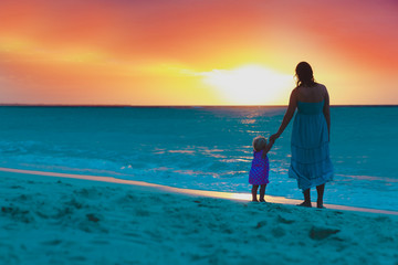 Fototapeta premium mother and little daughter enjoy sunset on beach