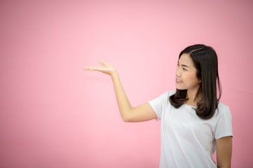 Portrait of a happy girl showing a gesture on a pink background