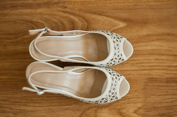 white bride shoes on wooden floor