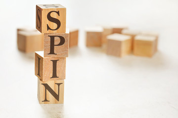 Four wooden cubes arranged in stack with word SPIN (meaning Solution Problem Implication Need) on...