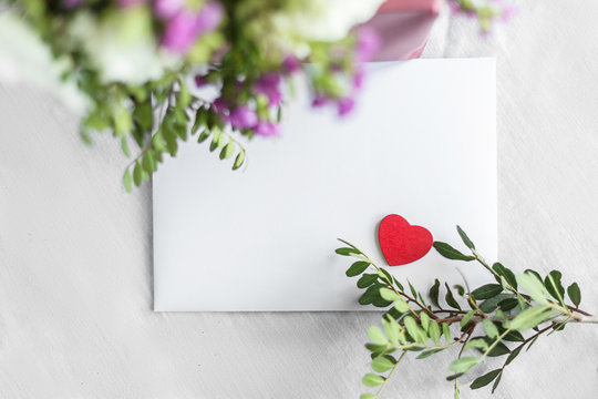 Letter and flowers on a white background. Invitation cards for a wedding or a love letter. Love concept, Happy mother's Day and Valentine's Day. the view from the top.copy space