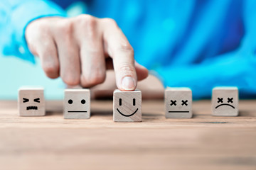 Businessman chooses a happy emoticon icons face.  Service, communication concept