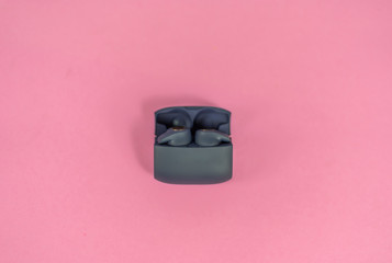Wireless headphones on pink table with background