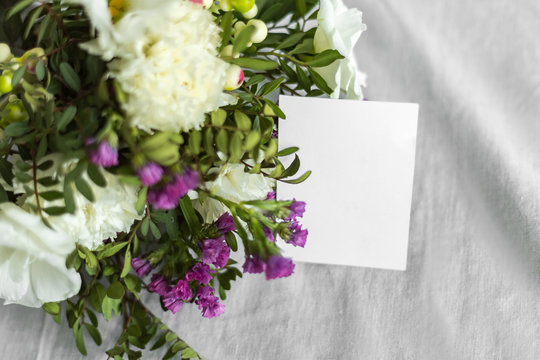 Postcard with a flowers and an empty tag for text. Romantic greeting and surprise. Concept of love, birthday, Happy mother's Day and Valentine's Day on white background. Selective focus. copy space