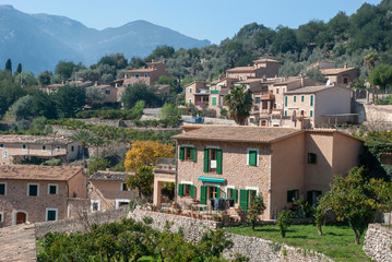 Blick über grünes Tal und mallorquinische Häuser in Fornalutx auf spanischer Baleareninsel Mallorca im Frühling
