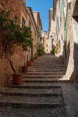 Alte enge Gasse mit Steinhäusern und Treppen in Fornalutx, Mallorca