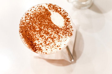 Tiramisu in a glass sprinkled with cocoa, trace from a spoon