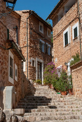 Fototapeta na wymiar Alte enge Gasse mit Steinhäusern und Treppen in Fornalutx, Mallorca