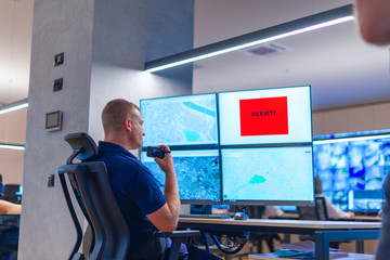 Male computer operator monitoring from a security ( computer, logistic ) center.