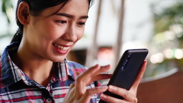 Close up face of asian woman hand holding mobile phone while using application.