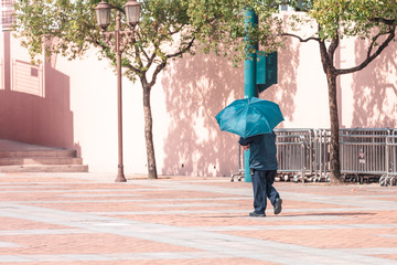Man walking with black umbrella in the Hong Kong park