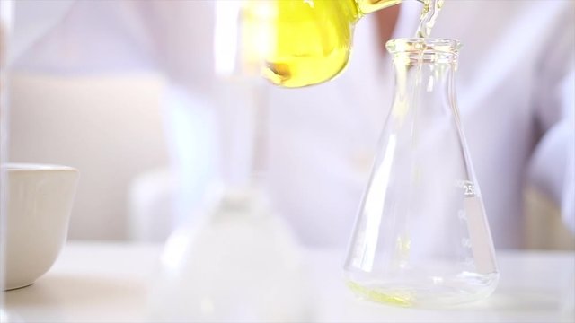 scientist make the medicine or the cosmetic in laboratory. pouring liquid or oil . pharmaceutical science technology concept.