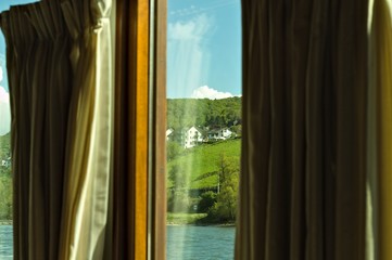 View of a german landscape through the glass of a window with curtains (Germany, Europe)