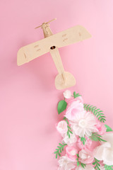 small wooden toy airplane lucky by flower