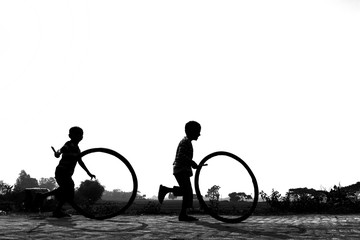Bangladesh – January 24, 2020: A restless boy is playing on the village road with old discarded...